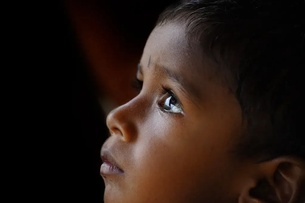 A young child looking towards the light