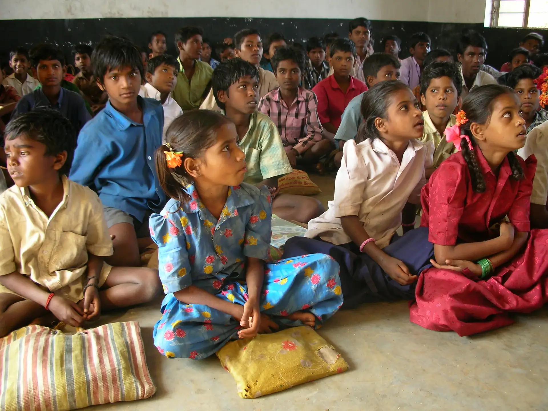 Children sitting together on the floor of a classroom
