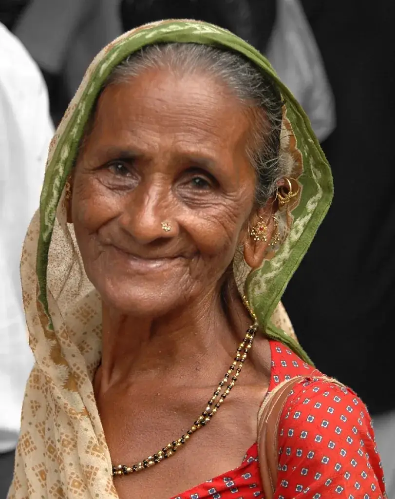An elderly woman in a green headscarf